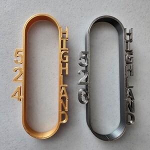 May include: Two metal keychains, one gold and one silver, with the word "HIGHLAND" and the numbers "524" and "526" printed on them.