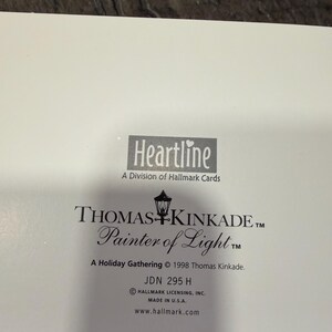 May include: A white card with the Heartline logo and text from Thomas Kinkade, "Painter of Light." The card includes the text "A Holiday Gathering &copy; 1998 Thomas Kinkade" and "Made in U.S.A."