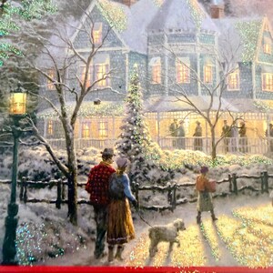 May include: A winter scene depicts a snow-covered house with lights and a Christmas tree. A couple walks a dog on a path, while another person walks in the distance. The image has a festive, holiday theme.