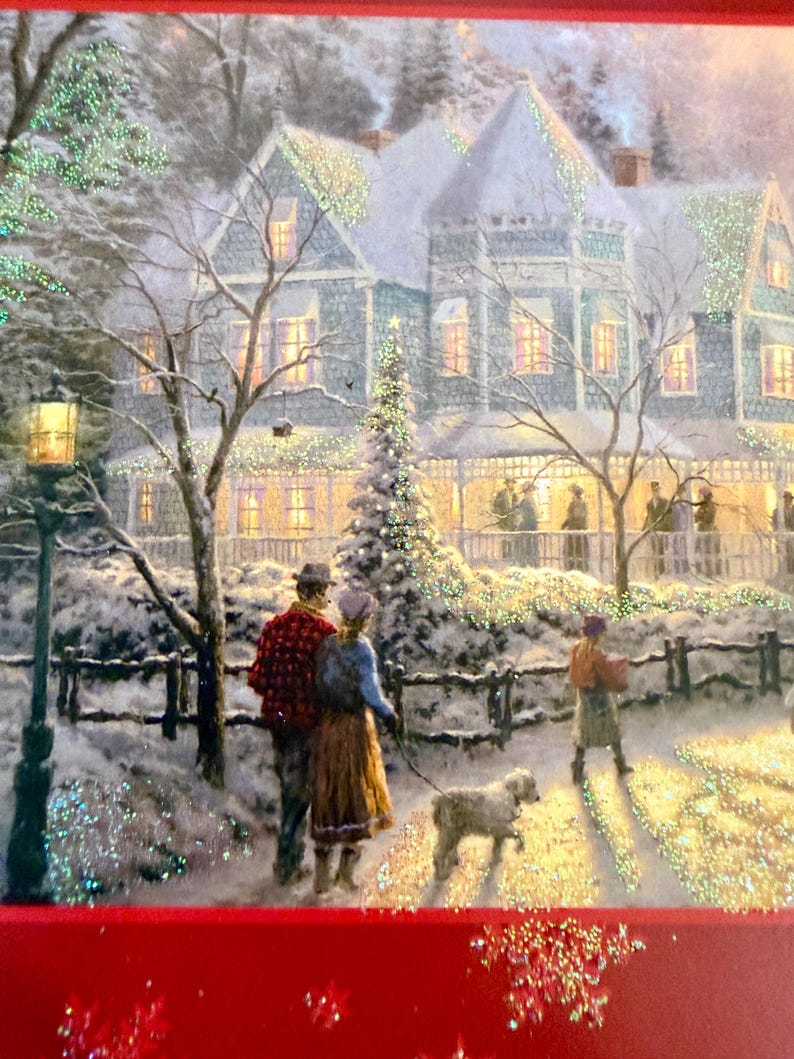 May include: A winter scene depicts a snow-covered house with lights and a Christmas tree. A couple walks a dog on a path, while another person walks in the distance. The image has a festive, holiday theme.