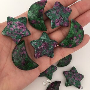 May include: A collection of green and pink star and crescent moon shaped stones. The stones are tumbled and polished.