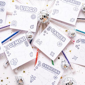 Peut inclure: Un ensemble de 12 cartes de signes du zodiaque imprimables avec un fond blanc et des contours noirs. Chaque carte présente un signe du zodiaque différent avec ses dates correspondantes. Les cartes sont entourées de stylos argentés à paillettes et de petites boules disco argentées.