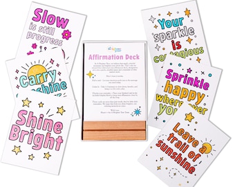 Könnte beinhalten: Ein Affirmationsdeck mit bunten Karten mit inspirierenden Sätzen wie "Shine Bright" und "Leave a trail of sunshine". Das Deck enthält einen Holzständer und Karten mit Stern- und Sonnenillustrationen.