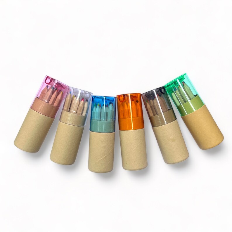 May include: Seven colorful pencil cases with a variety of colored pencils inside. The cases are made of cardboard and have a clear plastic top.