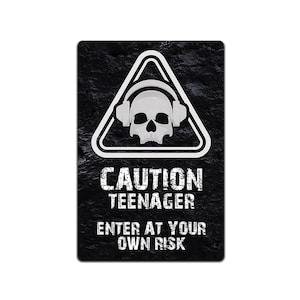 Może przedstawiać: Czarno-biały znak ostrzegawczy z czaszką w słuchawkach w trójkącie. Na znaku widnieje napis "Uwaga Nastolatek Wejście na własne ryzyko".