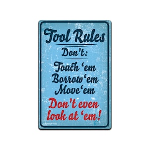 Op de afbeelding: Een blauw en wit metalen bord met de tekst "Tool Rules" en een lijst met regels: "Don't: Touch 'em Borrow 'em Move 'em Don't even look at 'em!"