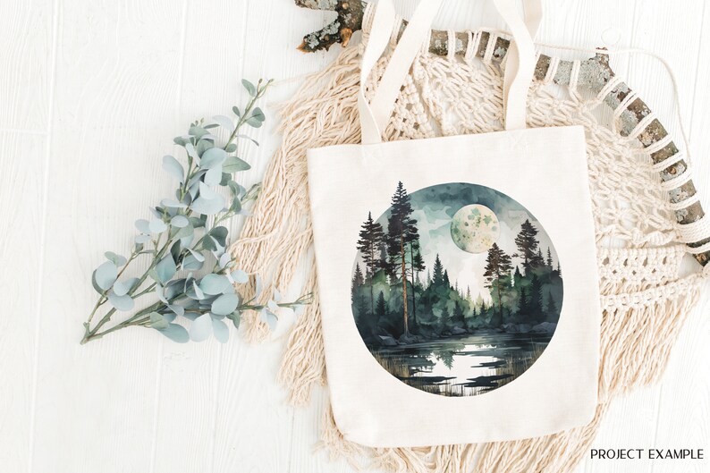 May include: A white canvas tote bag with a circular design featuring a watercolor painting of a moonlit forest scene. The scene includes a lake, trees, and a full moon.