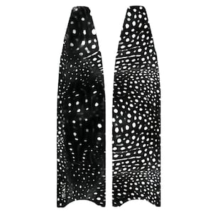 Puede incluir: Dos aletas de tabla de surf en blanco y negro con un patrón moteado. Las aletas son altas y estrechas, con una parte superior redondeada y una inferior puntiaguda. El patrón consiste en pequeños puntos blancos irregulares sobre un fondo negro.
