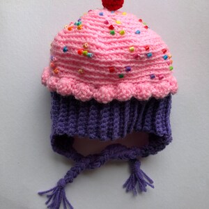 Puede incluir: Un gorro de cupcake tejido a crochet, rosa con cuentas de colores y una cereza roja. La base es morada con lazos trenzados. Un accesorio divertido y hecho a mano para ni&ntilde;os, ideal para disfraces.