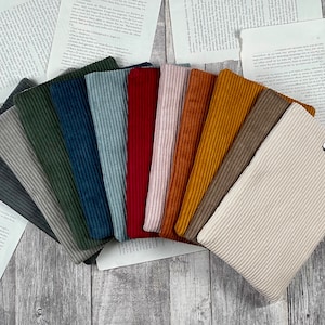 May include: A set of 10 fabric swatches in various colors, including gray, green, blue, red, orange, yellow, brown, and beige. The fabric has a corduroy texture.