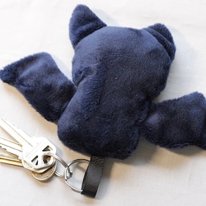 The back of the keychain is a solid dark blue minky fabric.