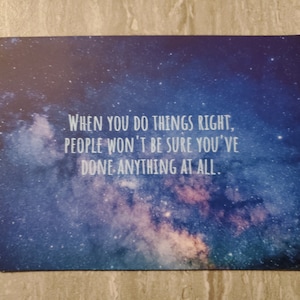 May include: A blue and purple galaxy-themed mousepad with the quote "WHEN YOU DO THINGS RIGHT, PEOPLE WON'T BE SURE YOU'VE DONE ANYTHING AT ALL."