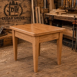 May include: A square wooden side table with a natural light brown finish and visible wood grain. The table features a flat top with rounded corners and four straight, slightly tapered legs. The construction is solid wood with a smooth surface.