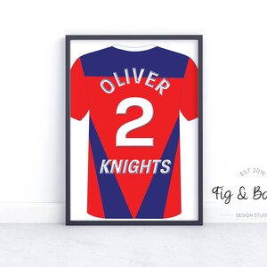 May include: A framed print of a red and blue jersey with the name "Oliver" and the number "2" on the back. The jersey also has the word "Knights" printed on the front.