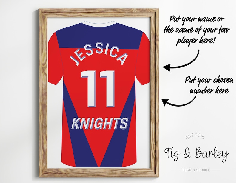 May include: A framed print of a red and blue sports jersey with the name "JESSICA" and the number "11" on the back. The jersey also has the word "KNIGHTS" printed on the bottom. The print is framed in a light brown wood frame.