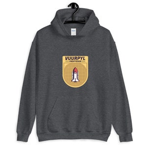 K&ouml;nnte beinhalten: Ein dunkelgrauer Hoodie mit einem gelben Patch, auf dem ein Raumschiff und der Text "VUURPYL PROFFESOR" abgebildet sind.