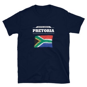May include: Navy blue t-shirt featuring the text "SOUTH AFRICA PRETORIA" above a distressed South African flag design. The shirt is a short-sleeved crew neck.