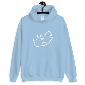 May include: Light blue hoodie with a white outline of the map of South Africa and the text "Born & Bred" on the front.