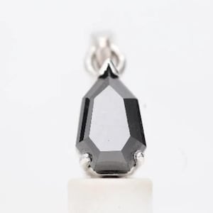 May include: A black diamond pendant with a teardrop shape, set in a silver setting.