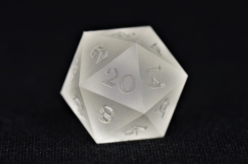 May include: A white, frosted twenty-sided die with numbers 2, 4, 6, 8, 10, 12, 14, 16, 18, 20, 1, 3, 5, 7, 9, 11, 13, 15, 17, and 19.