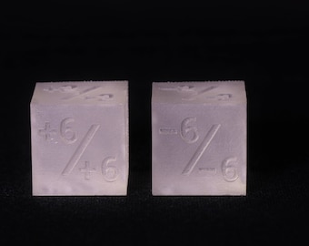 May include: Two white plastic dice with the number 6 on each side, one with a plus sign and one with a minus sign.