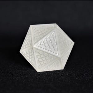 May include: A white, geometric, 3D printed dice with a textured surface.