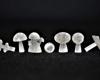 May include: A set of eight white, translucent, miniature mushroom figurines. The mushrooms are made of a smooth, glossy material and have a variety of shapes and sizes.
