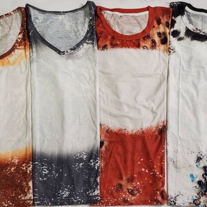 Puede incluir: Cuatro camisetas blancas con dise&ntilde;os &uacute;nicos. La primera tiene un efecto degradado marr&oacute;n y naranja, la segunda un degradado gris y blanco, la tercera un dise&ntilde;o rojo y estampado de leopardo, y la cuarta un patr&oacute;n en blanco y negro.