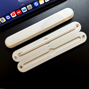 May include: A white Apple Pencil is in a white case. The case is made of two pieces that snap together. The case is open and the pencil is inside.
