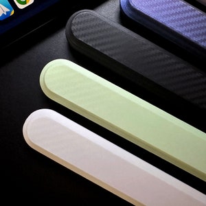 May include: Four different colored phone cases, one black with a carbon fiber pattern, one light green, one white, and one dark blue with a carbon fiber pattern.