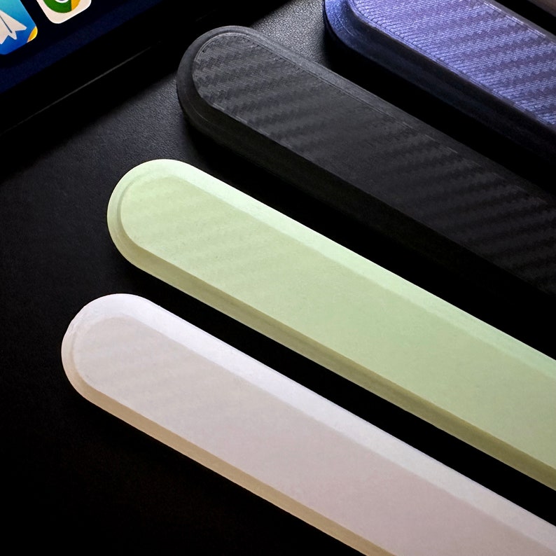 May include: Four different colored phone cases, one black with a carbon fiber pattern, one light green, one white, and one dark blue with a carbon fiber pattern.
