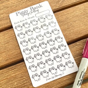 May include: A white sheet of stickers with a grid of 49 piggy bank illustrations. The text "Piggy Bank Savings Challenge" and "Each Icon Is Worth" is printed at the top of the sheet. The text "Dream Life Planning Co" is printed at the bottom of the sheet.