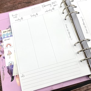 May include: A white paper planner insert for February 2027, week 7, featuring columns for Monday, Tuesday, and Wednesday. The page includes a section for habits, a notes area, and the text Dream Life Planning Co. A sticker sheet with a rainbow, mushroom, and flower is visible.