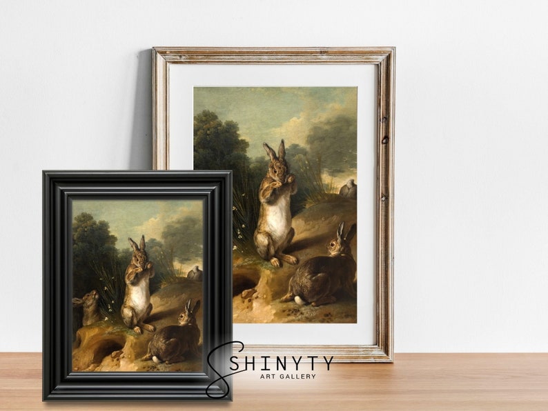 May include: A vintage oil painting depicting four rabbits in a woodland setting. The rabbits are brown and white with long ears and are depicted in a natural pose. The painting is framed in a black frame.