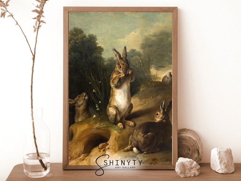 May include: A vintage oil painting depicting three brown rabbits in a woodland setting. The rabbits are in various poses, with one standing upright and two sitting. The painting has a warm, earthy color palette and a realistic style.