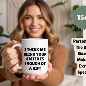 May include: White 425ml ceramic mug with the text "I THINK ME BEING YOUR SISTER IS ENOUGH OF A GIFT". The mug has a handle and is held by a person. The mug is a gift for a sister.