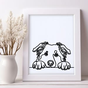 Puede incluir: Una impresi&oacute;n enmarcada en blanco y negro de un rostro de perro. El perro est&aacute; dibujado con una l&iacute;nea continua, con sus patas apoyadas en una l&iacute;nea horizontal. La obra de arte se muestra en un marco blanco.