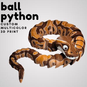 May include: A custom, multicolor 3D-printed ball python snake toy. The snake features a detailed design with brown, tan, and orange segments. The text "ball python" and "custom multicolor 3D print" are displayed in black.