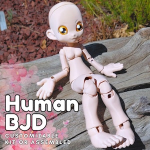 May include: A light beige Human BJD doll with large yellow eyes, articulated joints, and a smooth, unpainted surface. The doll is sitting on a piece of wood. Text on the image reads "Human BJD" and "Customizable Kit or Assembled."