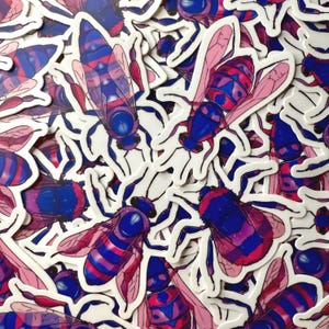 May include: A collection of stickers featuring a stylized insect design. The insects have blue bodies, pink and purple striped abdomens, and pink wings. The stickers are on a white background.