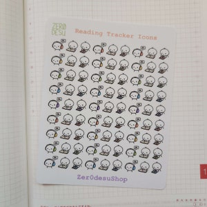 May include: A sheet of stickers featuring illustrations of cartoon characters reading books. The stickers are designed for use in a reading tracker. The text "ZERO DESU Reading Tracker Icons" is printed at the top of the sheet. The text "ZerodesuShop" is printed at the bottom of the sheet.