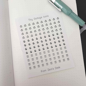 Puede incluir: Una hoja de papel blanco con iconos en blanco y negro de símbolos de reciclaje y botes de basura. El texto "Tiny Garbage Icons" y "From Zero's Desk" está impreso en la hoja.