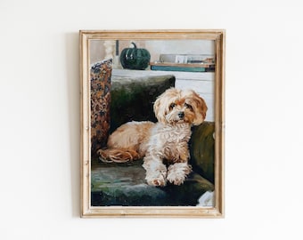 Op de afbeelding: Een ingelijst olieverfschilderij van een pluizige, lichtbruine hond die op een donkergroene bank ligt. Naast de hond ligt een kussen met een oranje en blauw patroon. Op de achtergrond staat een donkergroene pompoen op een witte plank.