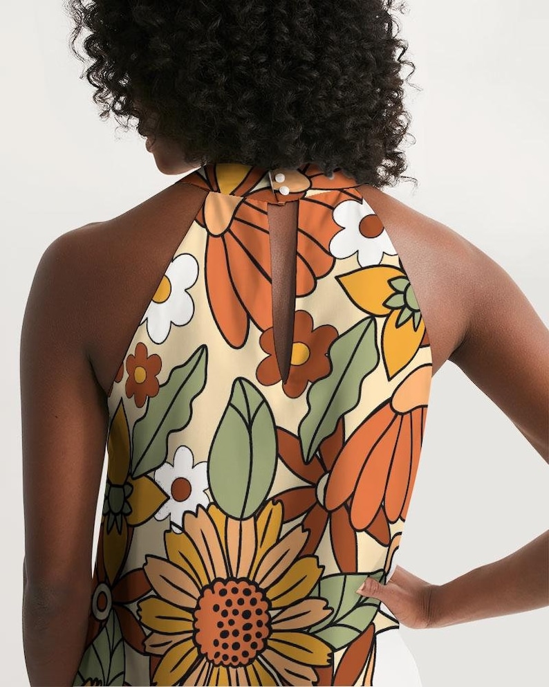May include: A halter top with a retro floral print in shades of orange, yellow, green, and white. The top has a keyhole back and a sleeveless design.