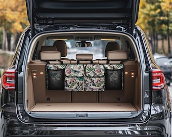May include: A black car with the back hatch open, revealing a backseat organizer with three compartments. The organizer has a floral and dragonfly print and is hanging from the headrests.