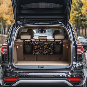 May include: Black car trunk organizer with three compartments. The center compartment features a colorful mushroom and fern pattern on a black background. The side compartments are black mesh.