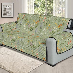 May include: A green floral sofa cover with a quilted pattern. The cover features a variety of flowers in shades of pink, yellow, and white.