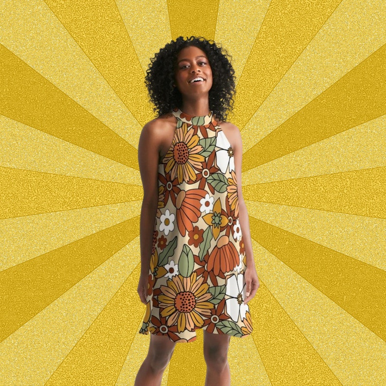 May include: A woman wearing a sleeveless halter dress with a retro floral print in shades of orange, brown, green, and white. The dress has a fitted bodice and a flowing skirt.