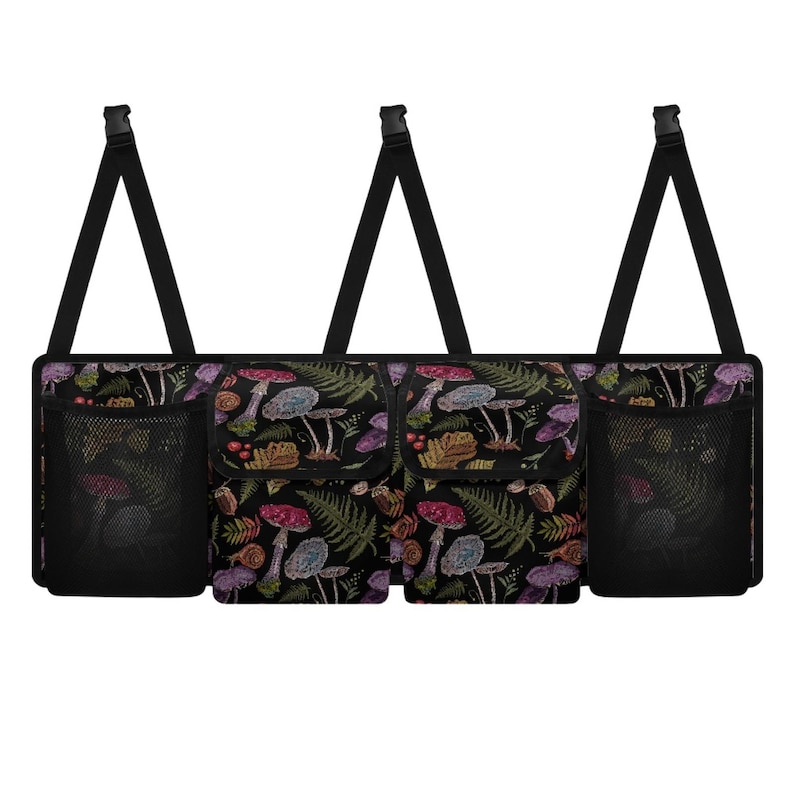 May include: Black car organizer with a colorful mushroom and fern pattern. Features two mesh pockets and two additional pockets. Adjustable black straps with plastic clips for easy attachment. A practical accessory for car organization.