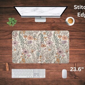 May include: A floral patterned mouse pad with stitched edges. The mouse pad is 23.6 inches by 16 inches and features a light beige background with a variety of pink, yellow, and green flowers.